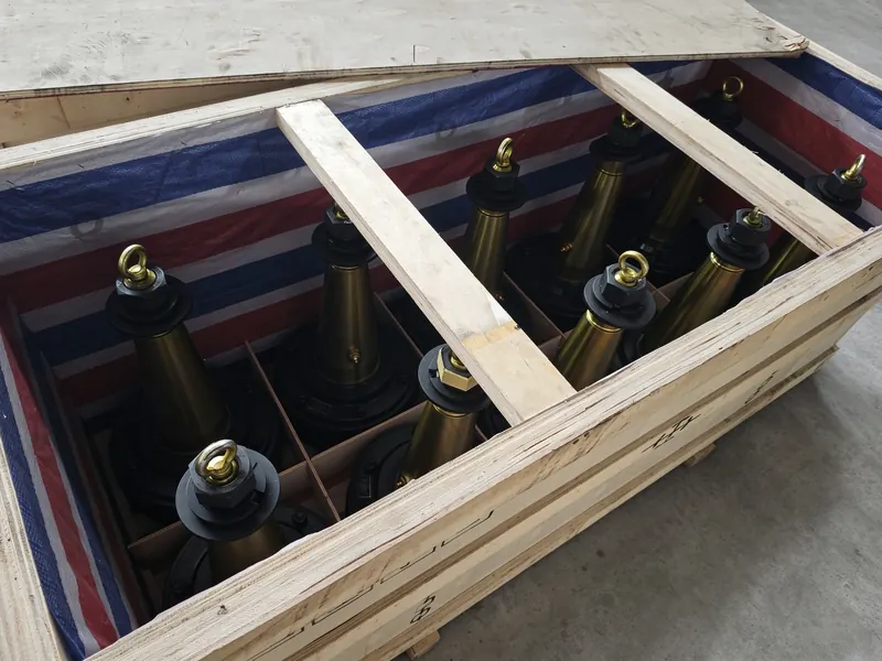 Rods with lifting eyes stood upright, one per compartment, inside a lined export crate.